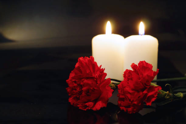 istock Two burning candles with flowers 1179371116