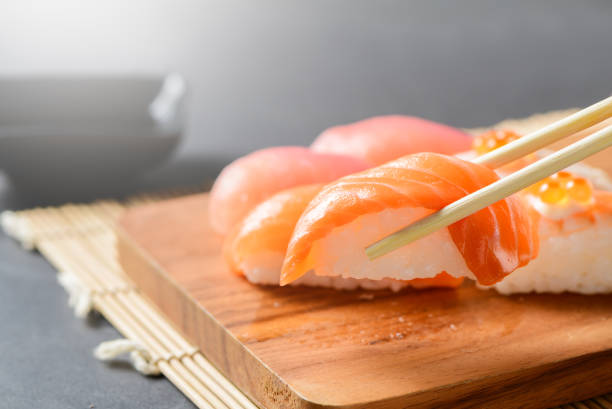 istock Salmon sushi nigiri in chopsticks 1179372233