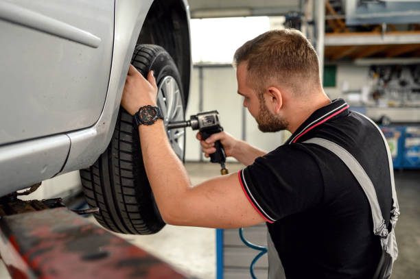 istock Car mechanic is changing tire 1179373222