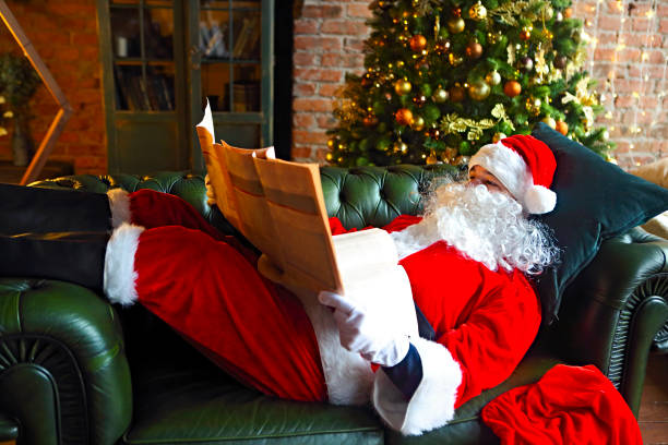 istock Santa claus reading business newspaper while sitting on sofa 1179378723