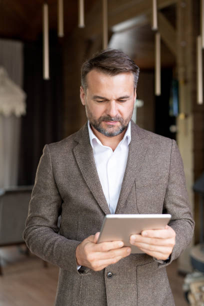 istock Serious entrepreneur in formalwear holding touchpad while surfing in the net 1179380910