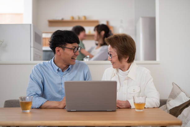 senior woman learning how to use digital device in family - wireless technology cheerful granddaughter grandmother imagens e fotografias de stock