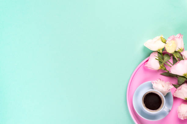 istock Cup of coffee with bouquet pink eustoma on a rose tray over blue background with copy space, flat lay. Valentines day, birthday, mother or wedding greeting card 1179383913