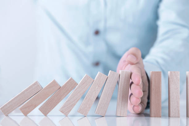 Businessman hand stopping the domino effect for management and Solution , concept strategy and successful intervention stock photo