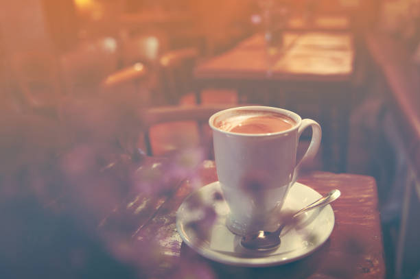 istock Close up white coffee latte cup on table near window with sun flare 1179385914