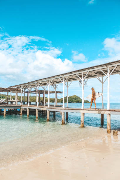 istock Woman walking on the pier going surfing 1179387051