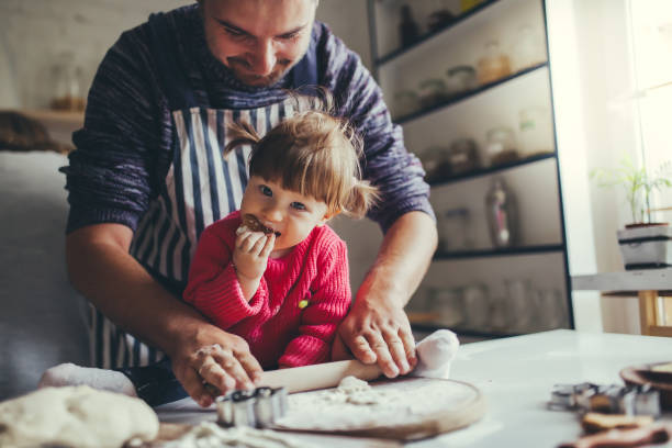happy family in the kitchen. father and daughter are preparing the christmas cookies. - family mother domestic life food imagens e fotografias de stock