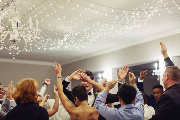After the formalities, we party! Shot of a young couple dancing with their friends at their wedding reception dance floor stock pictures, royalty-free photos & images