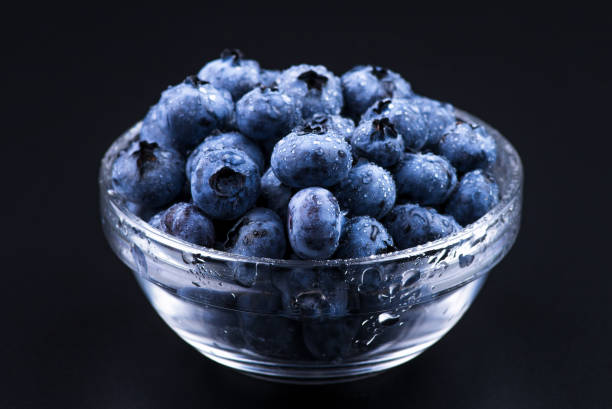 istock Close-up background. Fresh Blueberry Background. Texture blueberry berries close up. Various fresh summer berries. Blue food. Blueberries in a glass plate on a black background 1179390076