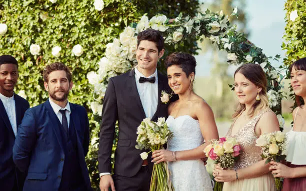 Portrait of a happy young couple standing with their bridesmaids and groomsmen on their wedding day