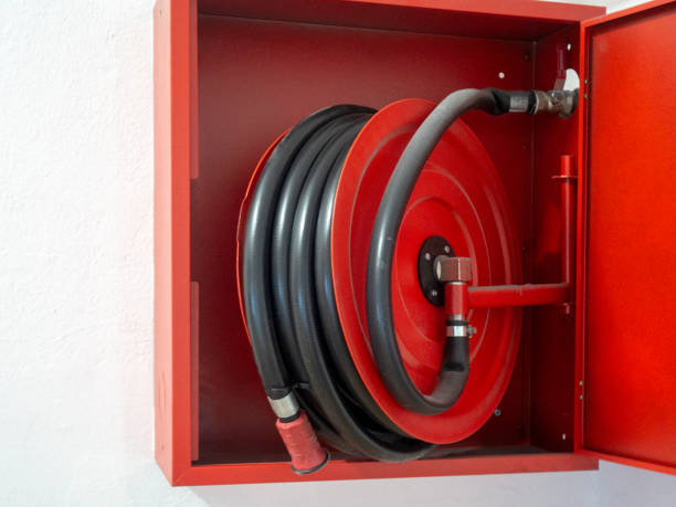 istock Wall mounted fire water hoses and fire fighting equipment on red cabinet 1179393603
