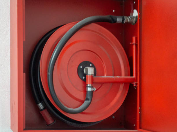 istock Wall mounted fire water hoses and fire fighting equipment on red cabinet 1179395355
