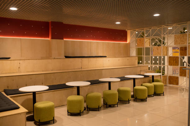 istock Row of soft velvet chairs by white small round tables inside modern cafe 1179396039