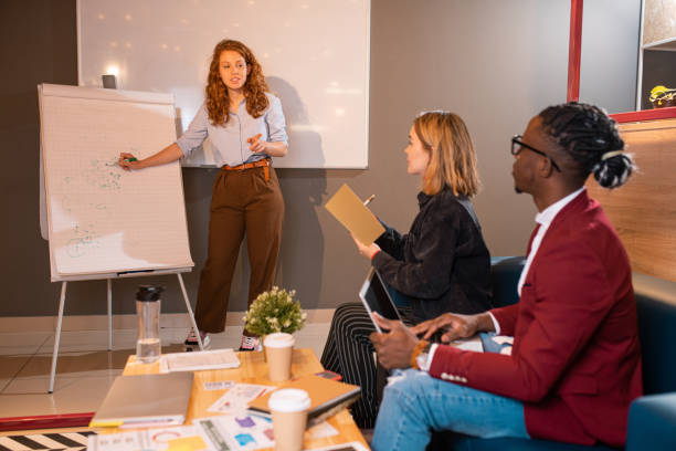 istock Young confident female employee explaining her colleagues some of working ideas 1179396682