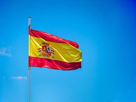 National Spanish flag in blue sky with clouds Spain waving
