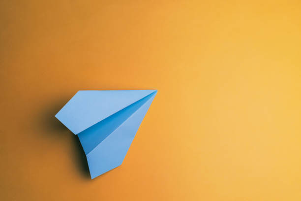 airplane paper origami on yellow background stock photo