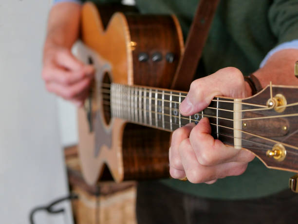 istock A man standing playing a guitar, with the focus on his left hand 1179402165