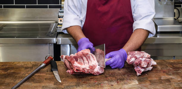 istock Butcher cuts meat in super market 1179402823