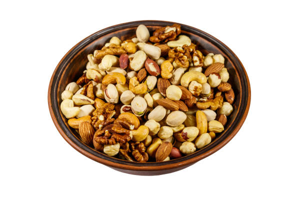 istock Bowl with mixed nuts isolated on white background. Walnuts, pistachio, almond, peanut, cashew, hazelnut in ceramic bowl 1179402967