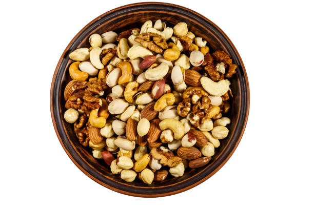 istock Bowl with mixed nuts isolated on white background. Walnuts, pistachio, almond, peanut, cashew, hazelnut in ceramic bowl. Top view 1179402968