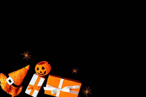 istock Flat lay of Halloween background with gift box decorative pumpkins, witch hat and spiders on black background. Copy Space for text 1179402995
