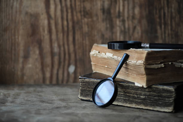 istock Old books on a wooden table and magnifier 1179403301