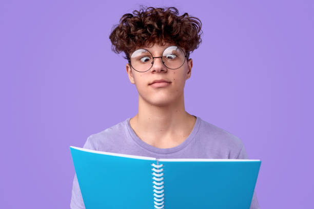 zabawny nastolatek czytanie notatnik - child cross eyed nerd eyewear zdjęcia i obrazy z banku zdjęć