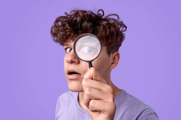 istock Funny teenager looking through magnifying glass 1179404617