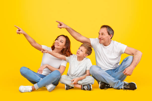 istock Happy family pointing aside together 1179404716