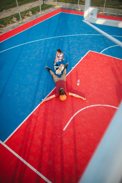 istock High angle view of father and son relaxing after basket 1179405417