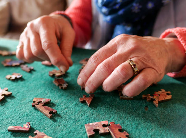 istock A woman sitting at a table doing a jigsaw puzzle 1179406412
