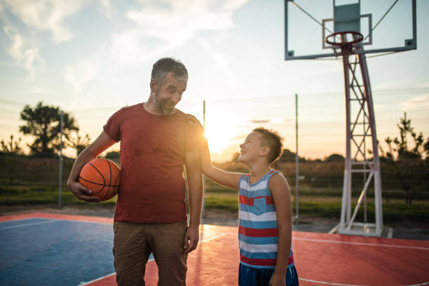 istock Daddy and son on basketball court on sunset 1179406443