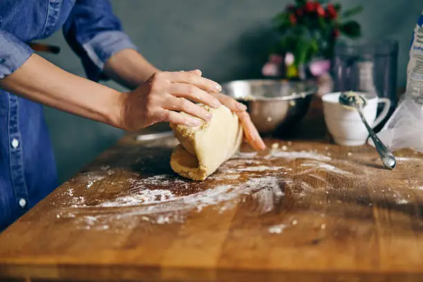 Photo of Young adult woman cooking holiday cookies in winter season at home