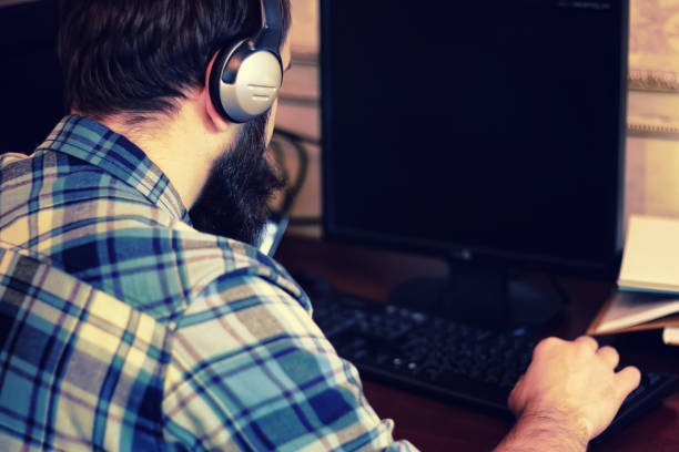istock male behind computer with headphones 1179407172