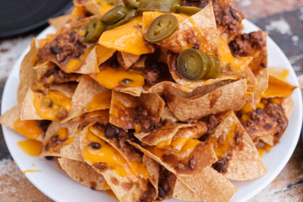 istock Beef and Bean Nachos  with jalapenos and melted cheese a on a rustic wood background. 1179408561