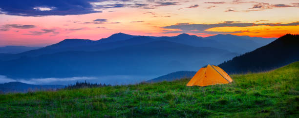 istock Orange tent in the mountains at sunset 1179409452