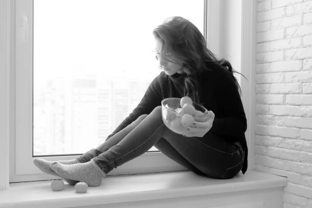 istock Girl at the window black and white 1179409630