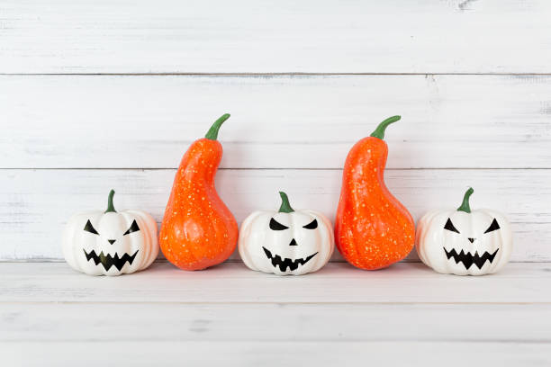 istock White ghost and Orange pumpkin on white wood table with copy space. 1179410250