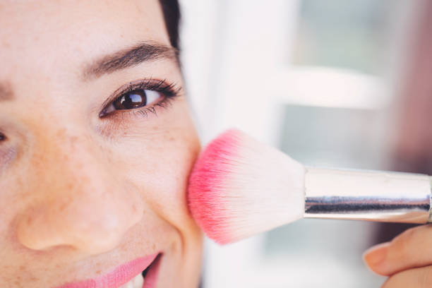 menina bonita com escova cosmética do pó para a composição. maquiagem. make-up aplicando para a pele perfeita. - blush - fotografias e filmes do acervo