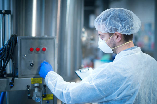 istock Technologist in protective uniform operating industrial machine in factory production line. 1179413770