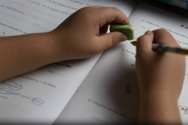 istock Hands of a child doing homework with a pencil and an eraser. 1179417008