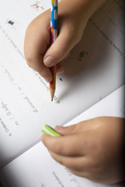 istock Hands of a child doing homework with a pencil and an eraser. 1179417016
