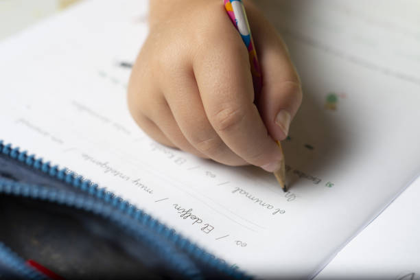 istock Hands of a child doing homework with a pencil and an eraser. 1179417031