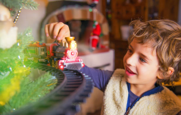 istock Handsome Young Boy Playing with Toy Christmas Tree Train 1179417133