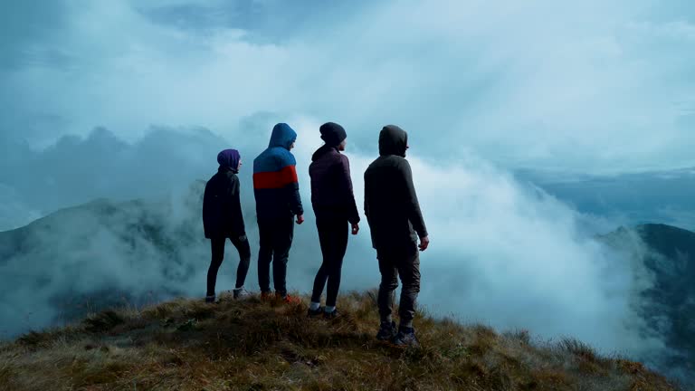 The four people standing on a picturesque mountain