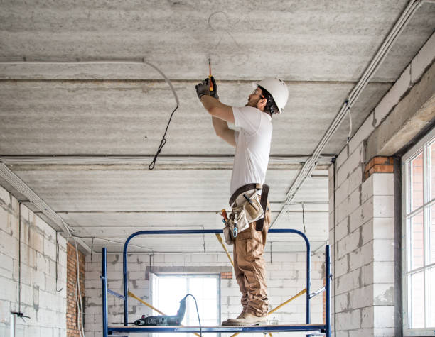electrician installer with a tool in his hands, working with cable on the construction site. - electrical contractor imagens e fotografias de stock