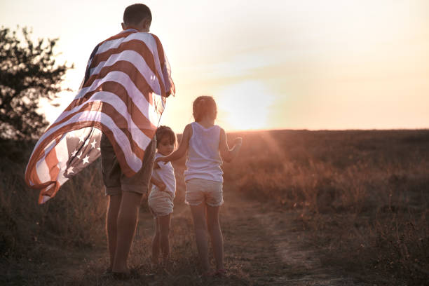 istock A happy family with an American flag at sunset. 1179420607