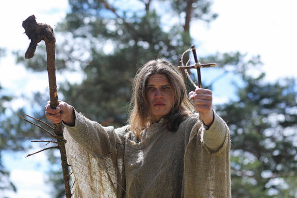 A man in a cassock spends a ritual in a dark forest