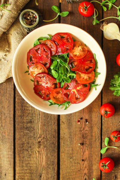 istock healthy salad tomatoes (vegetables, onions, greens, lettuce, sunflowers, microgreens and more) menu concept. food background. copy space. Top view 1179435547