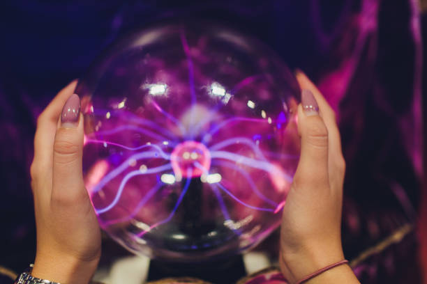 istock Hand touching a plasma ball with smooth magenta-blue flames. 1179436069